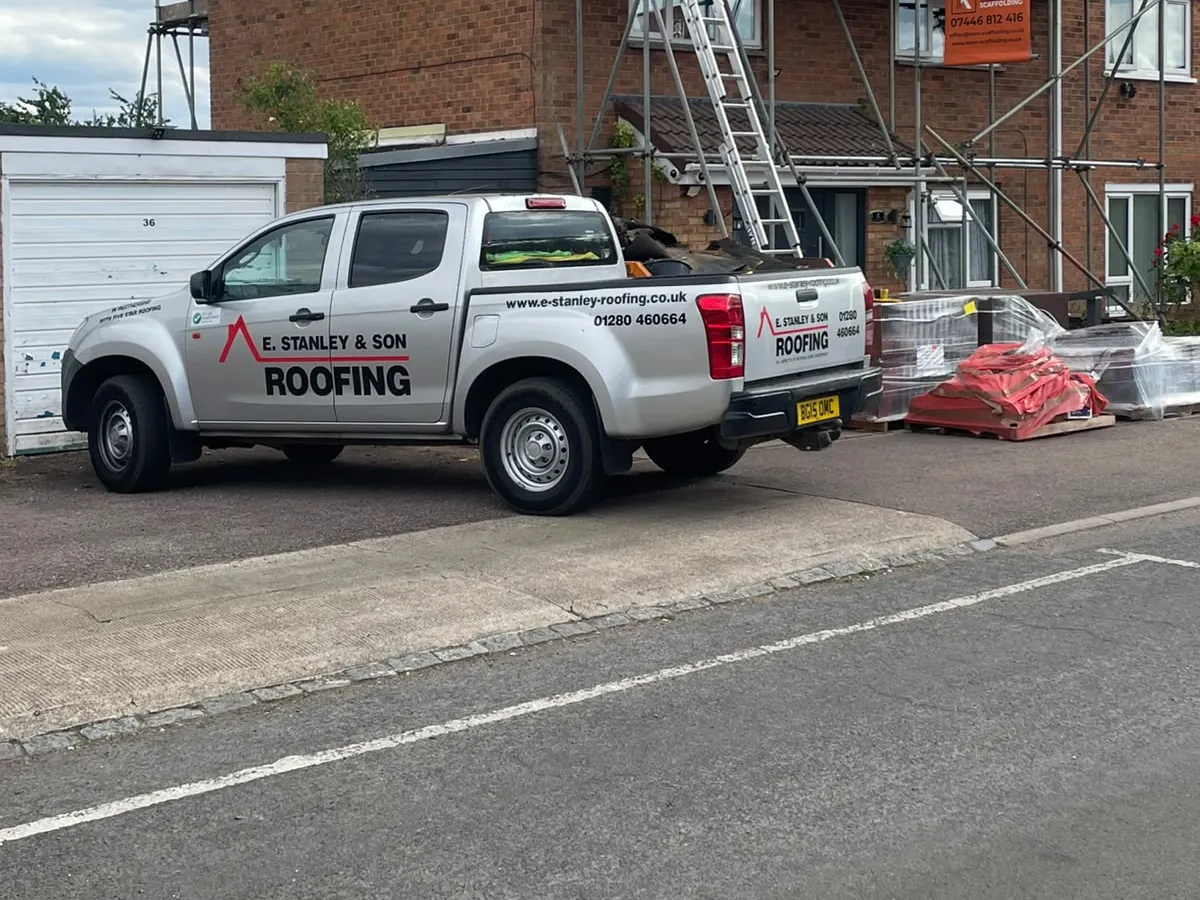 Company van outside a scaffolded re-roof